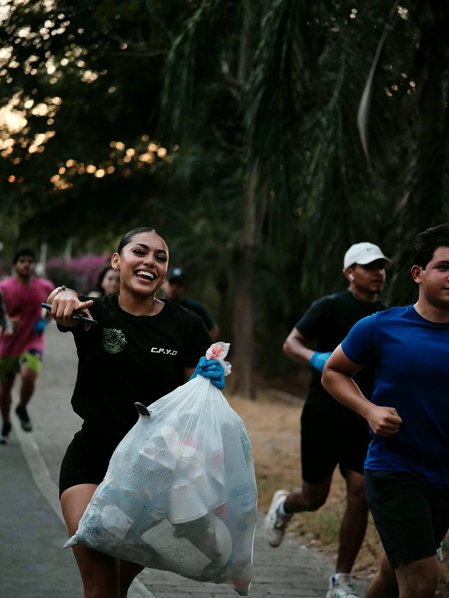 Runner sonriendo con una bolsa llena de basura en el Parque Lineal